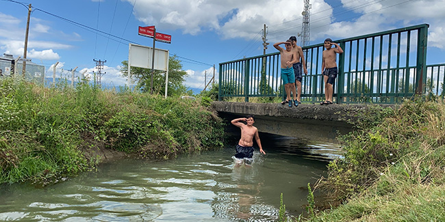 Sıcaktan bunalan çocuklar sulama kanalında serinledi