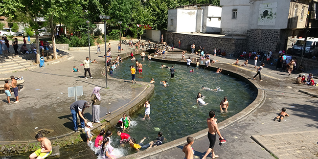 Diyarbakır’da sıcaktan bunalan çocuklar süs havuzlarını doldurdu