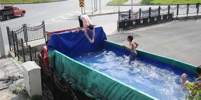 Havuza dönüştürülen kamyon kasasında yüzen çocuklara sürpriz