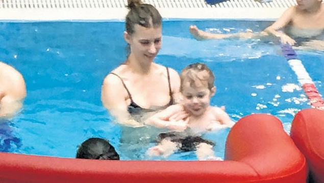 Çocuğuna yüzme öğretiyor